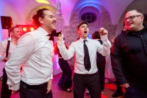 Esküvő fotózás külföldön - Party - vicces színes esküvői kép a vőlegényről és a bestmanekről buli közben.