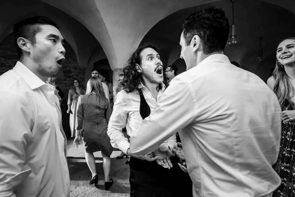Esküvő fotózás külföldön - Party - vicces fekete fehér esküvői kép a vőlegényről és a barátairól buli közben.
